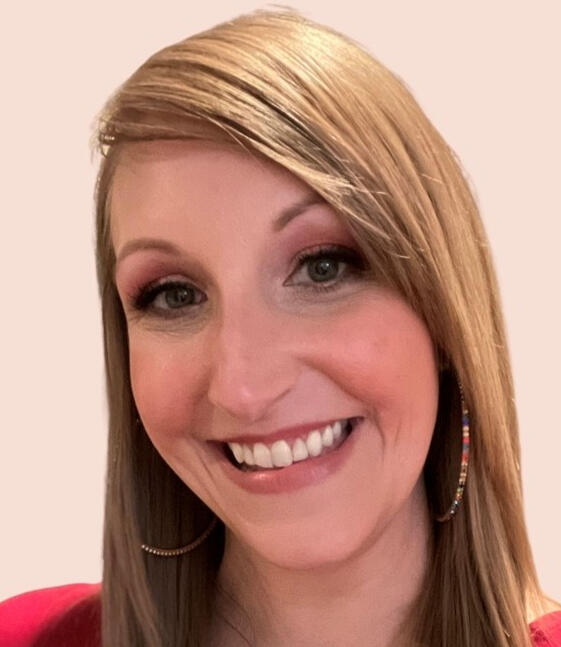 Woman with long blonde hair and hoop earrings smiling